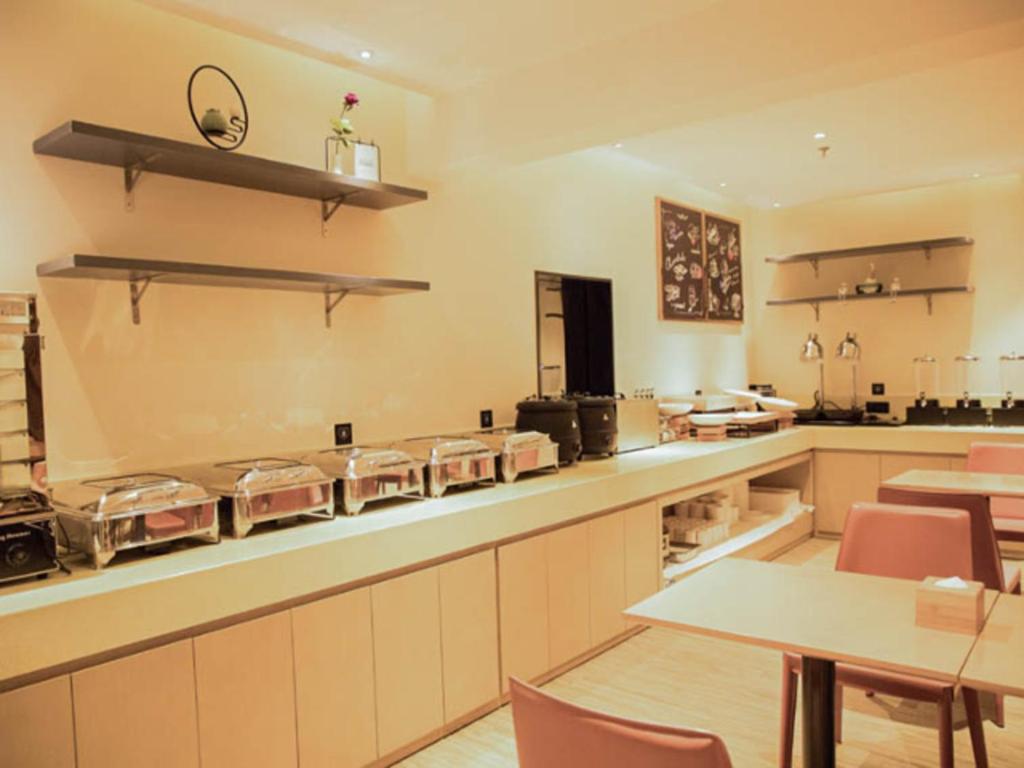 uma grande cozinha com um balcão com muitas panelas em City Comfort Inn Huaihua East Station em Huaihua