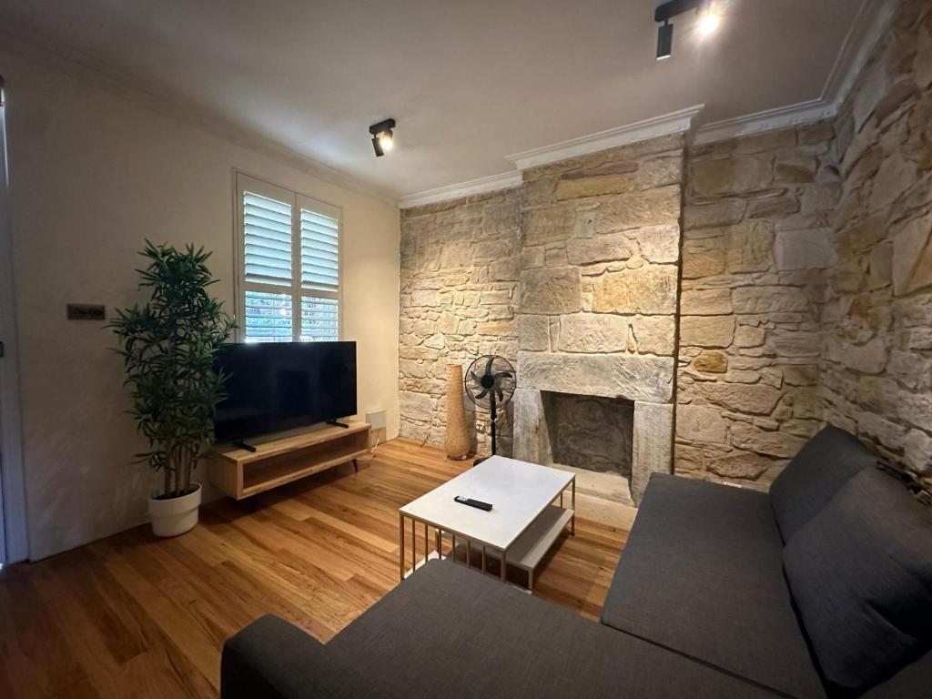 a living room with a stone fireplace and a couch at 2 Bedroom Family Friendly Ultimo Near the Centre 2 E-Bikes Included in Sydney