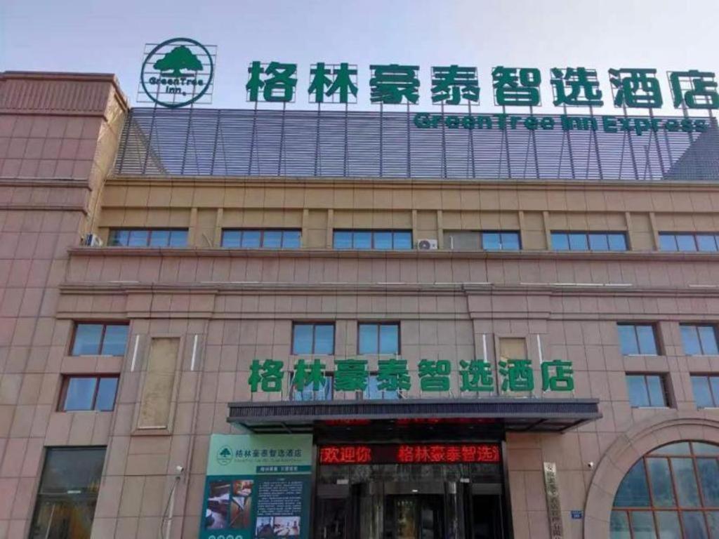 un edificio con un cartello sopra di Green Tree Inn Express Anhui Bozhou Mengcheng County Chengnan New District a Zhuangzhou