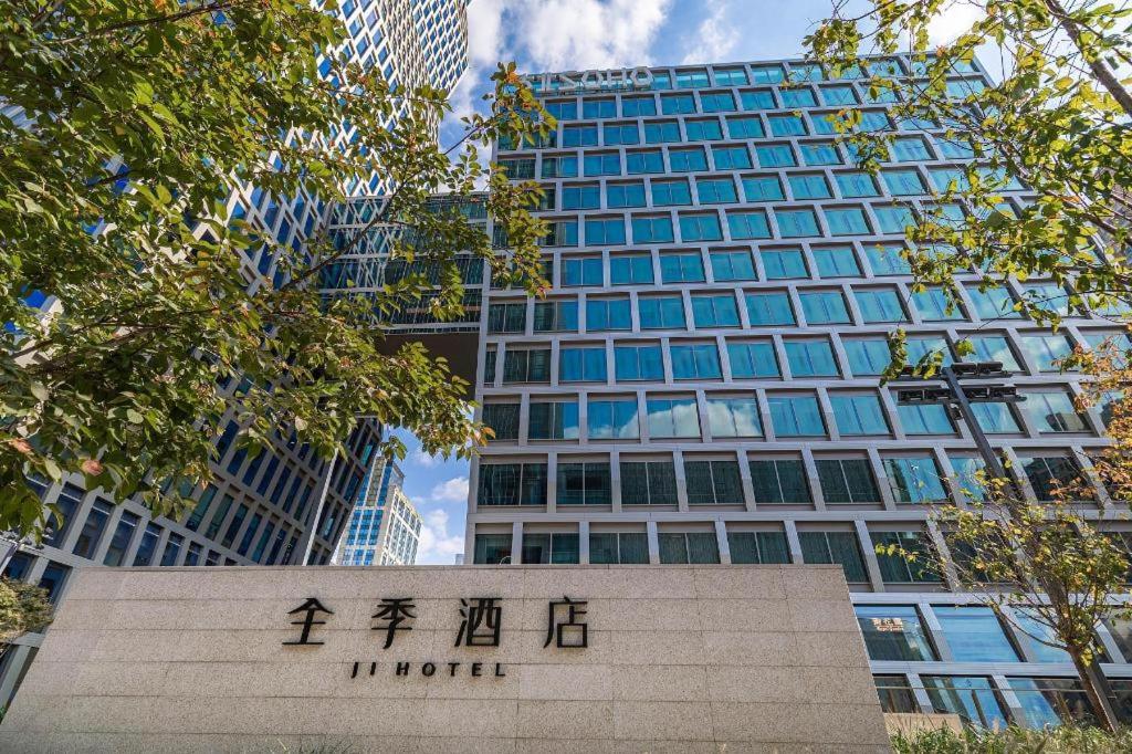 a sign in front of a tall building at Ji Hotel Shanghai Hongqiao Gubei Fortune Center in Shanghai