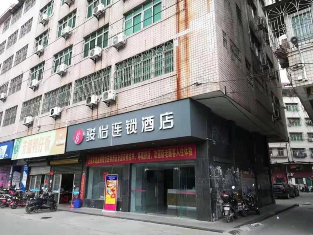 budynek z znakiem na boku w obiekcie Jun Hotel Guangdong Zhanjiang Xiashan South Railway Station w mieście Zhanjiang