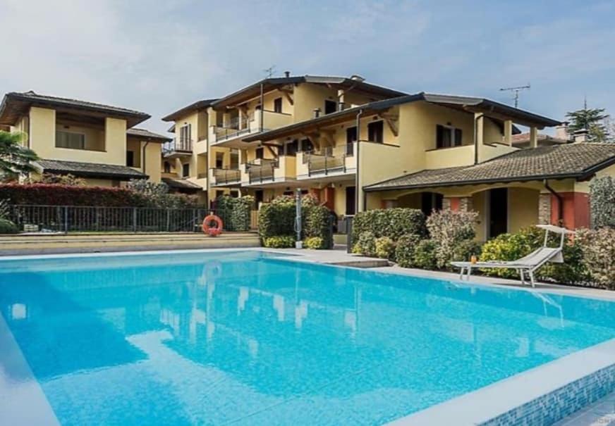 una gran piscina frente a una casa en HOYA APARTMENT, en Sirmione