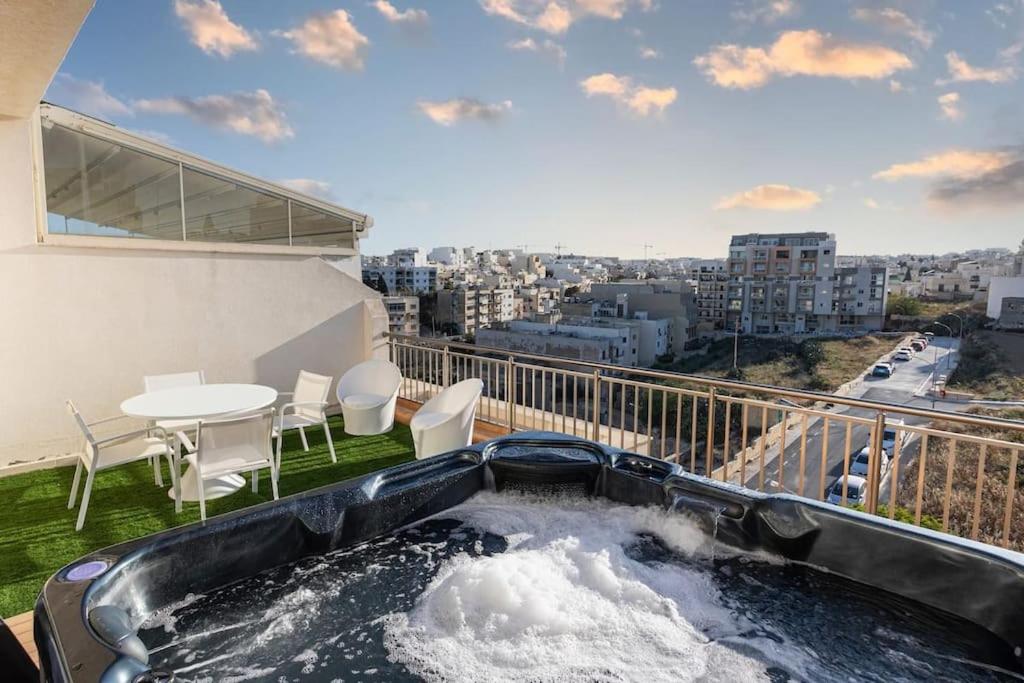 - Balcón con bañera de hidromasaje, mesa y sillas en Modern two bedroom penthouse! en St Julian's
