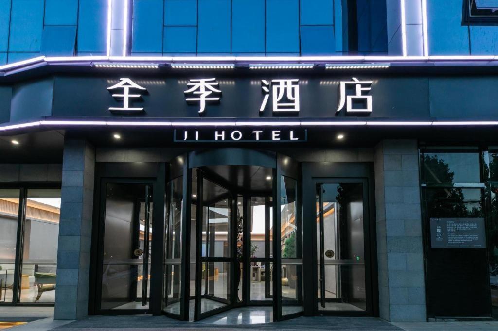 een hotel met openslaande deuren naar een gebouw bij Ji Hotel Gu'an Daxing International Airport in Gu'an