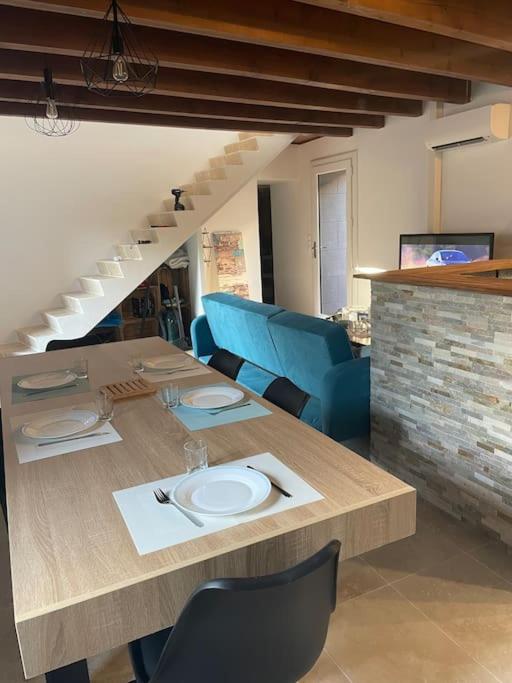 une table et des chaises avec une table et un escalier dans l'établissement Lou Castel, à Pomérols