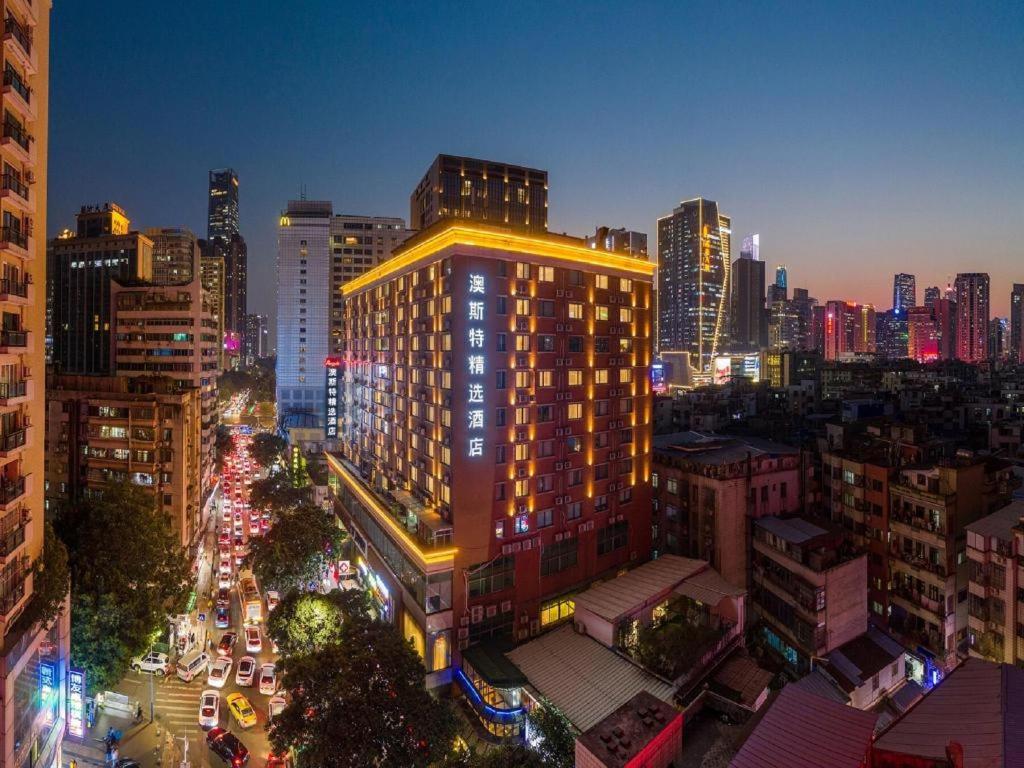 a city lit up at night with traffic on a street at Ausotel Smart (Zhujiang Newtown Guangzhou) in Guangzhou