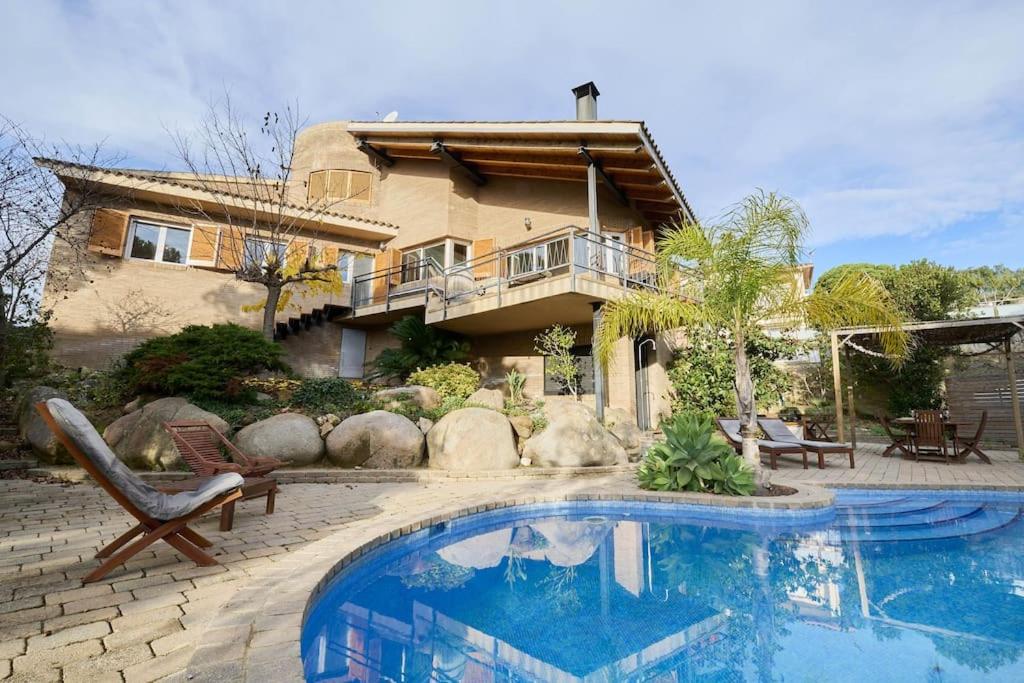 una casa con piscina frente a una casa en SeaHomes Vacations - VILLA ROYER, en Tordera