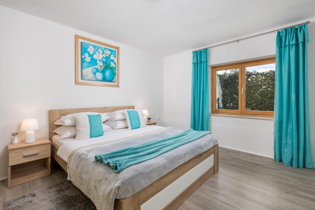 1 dormitorio con 1 cama con cortinas azules y ventana en Laurus apartments, en Rijeka
