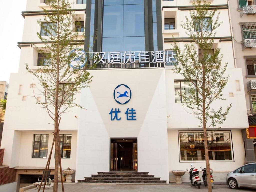 a building with a sign on the front of it at Hanting Premium Hotel Youjia Dengfeng Terminal in Dengfeng