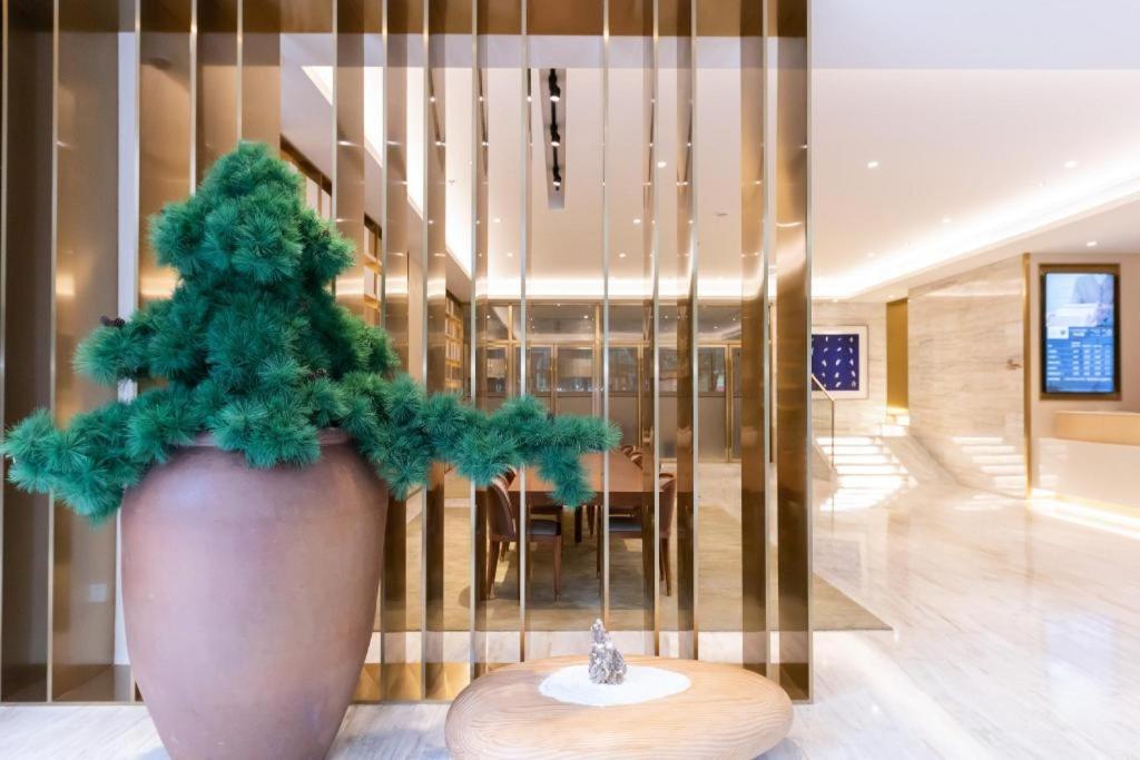 un grande vaso con una pianta verde nella hall di Ji Hotel Shanghai Jiangning Road Metro Station a Shanghai