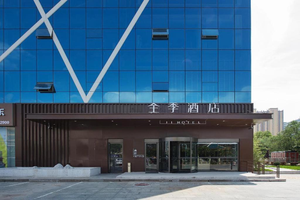 un gran edificio de cristal con un cartel. en Ji Hotel Changzhi Xi Bus Station, en Changzhi