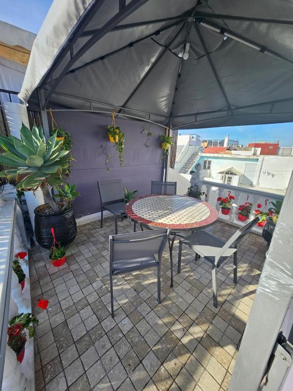 a patio with a table and chairs and an umbrella at Dar Bargach in Tangier