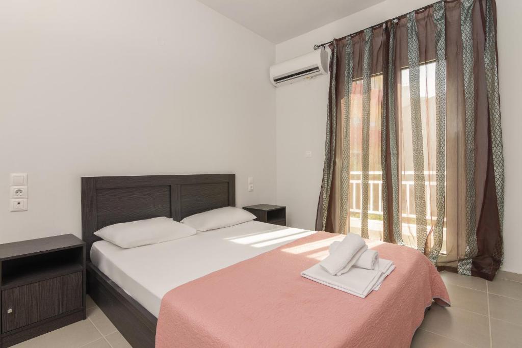 - une chambre avec un grand lit et une fenêtre dans l'établissement Comfy apartment for 6 people in Heraklion, à Héraklion