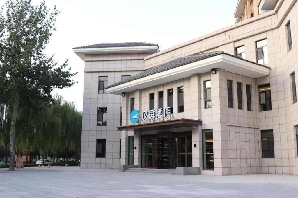 un bâtiment avec un panneau à l'avant dans l'établissement Hanting Hotel Yuncheng Xinjiangjiangzhou Avenue, à Xinjiang