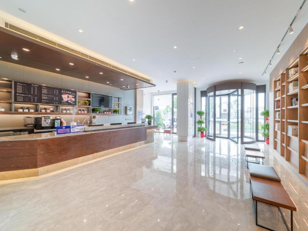 Hanting Premium Hotel Youjia Wuhan Etouwan Metro Station في Wujiashan: لوبي فندق مع كونتر وكراسي