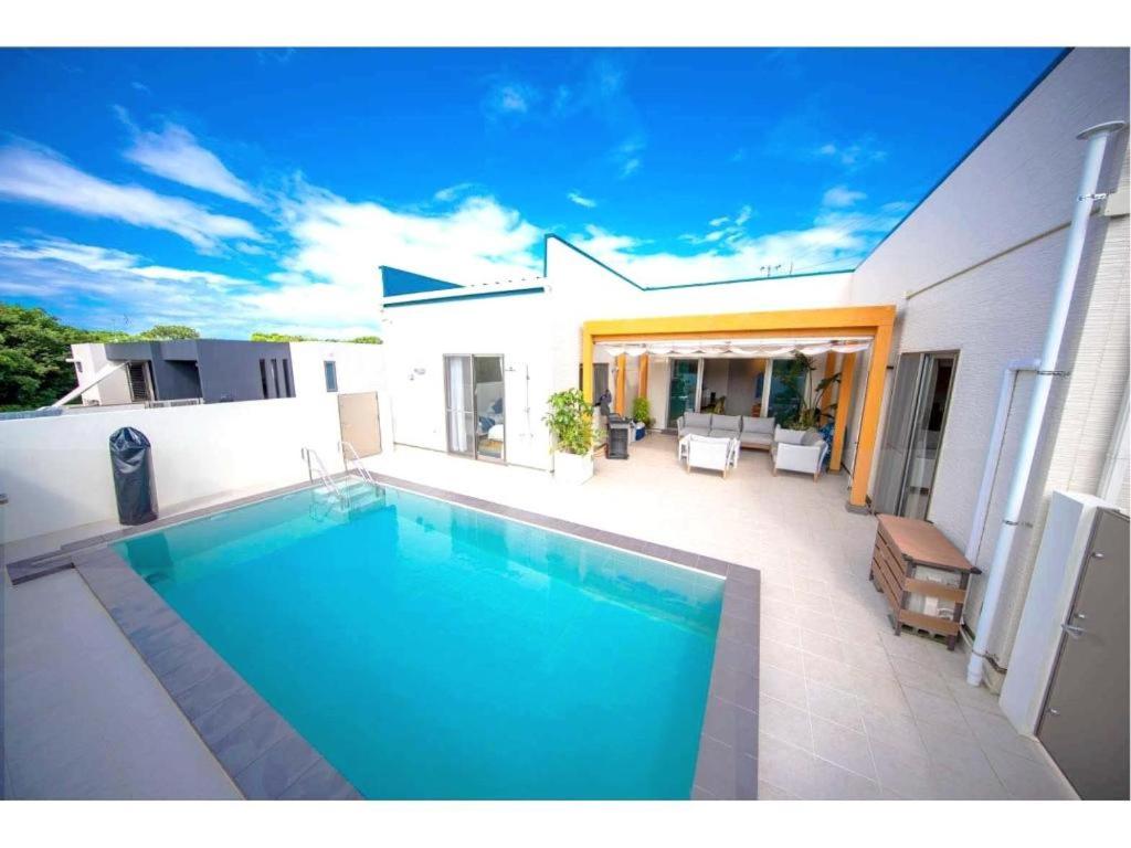 a swimming pool in the backyard of a house at Churaumi Village Pool and Terrace in Kitazato