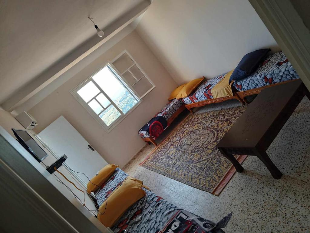 ein kleines Schlafzimmer mit einem Bett und einem Fenster in der Unterkunft tres belle vue sur la mer in Collo