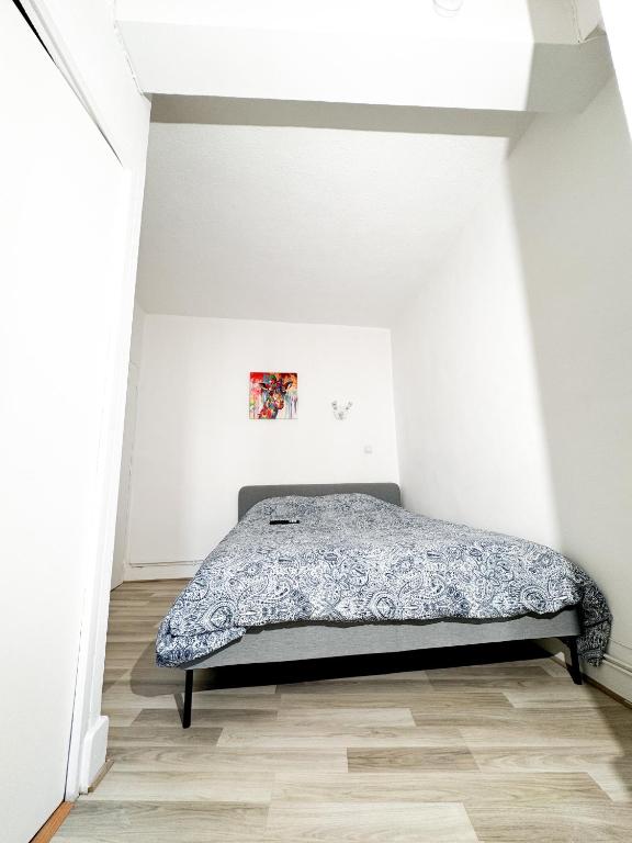 - une chambre avec un lit dans un mur blanc dans l'établissement Studio St Ursule R1, à Montpellier