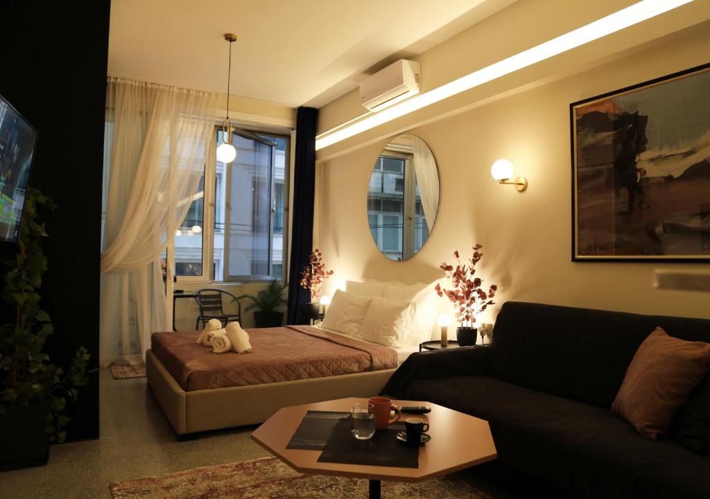 een woonkamer met een bed en een bank bij Syntagma Sweet House 4 in Athene