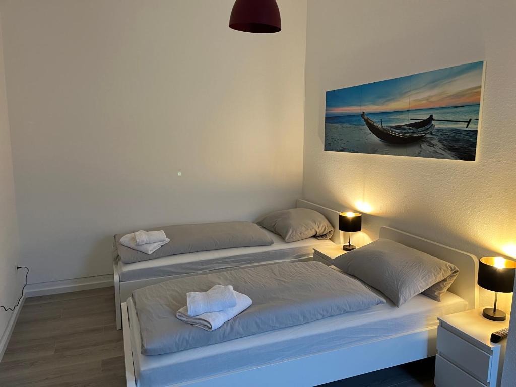 two beds in a room with a picture of a boat at Nauheim-Residenz in Bad Nauheim