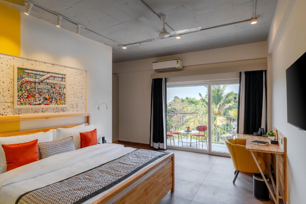 a hotel room with a bed and a balcony at Bedzzz Xclusiv Morjim, Goa By Leisure Hotels in Morjim