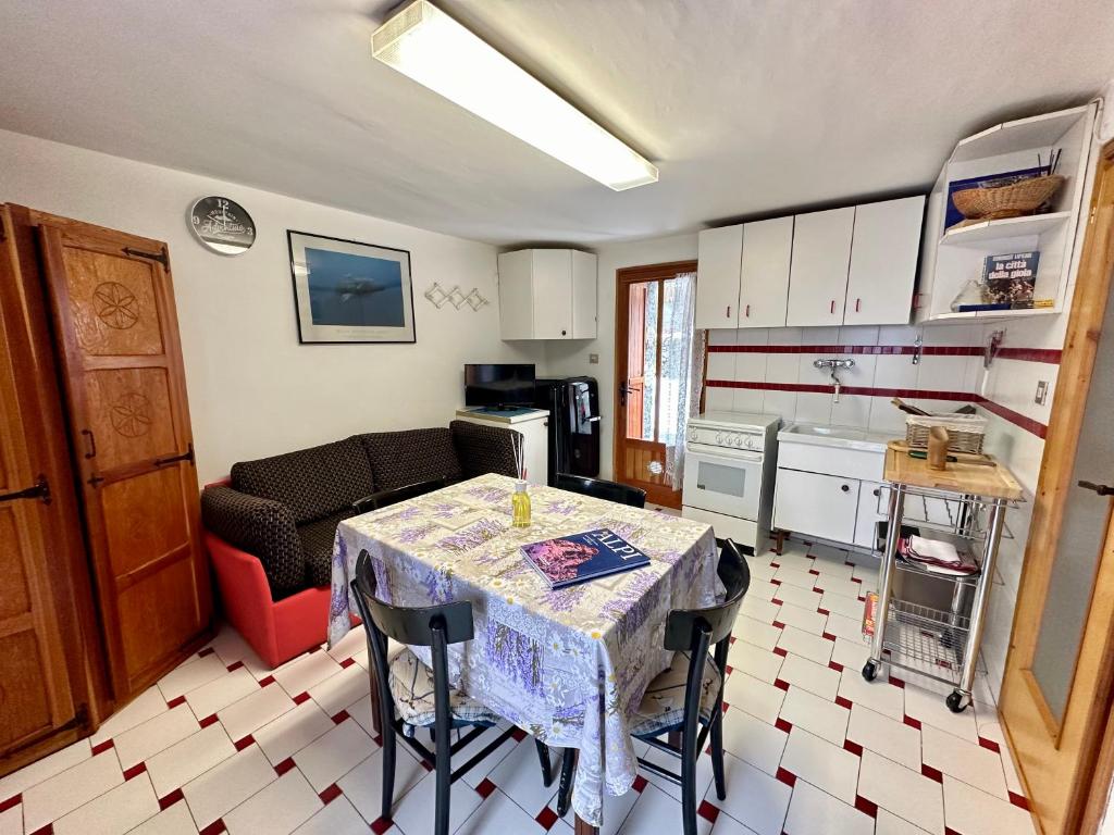 ein Wohnzimmer mit einem Tisch und einer Küche in der Unterkunft Cozy Chalet With Mountain Views in Ussin, Valtourneche, Parking in Chamois