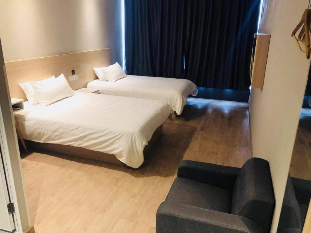a hotel room with two beds and a couch at Hi Inn Nanjing Xingang Development Zone in Qianjiadu