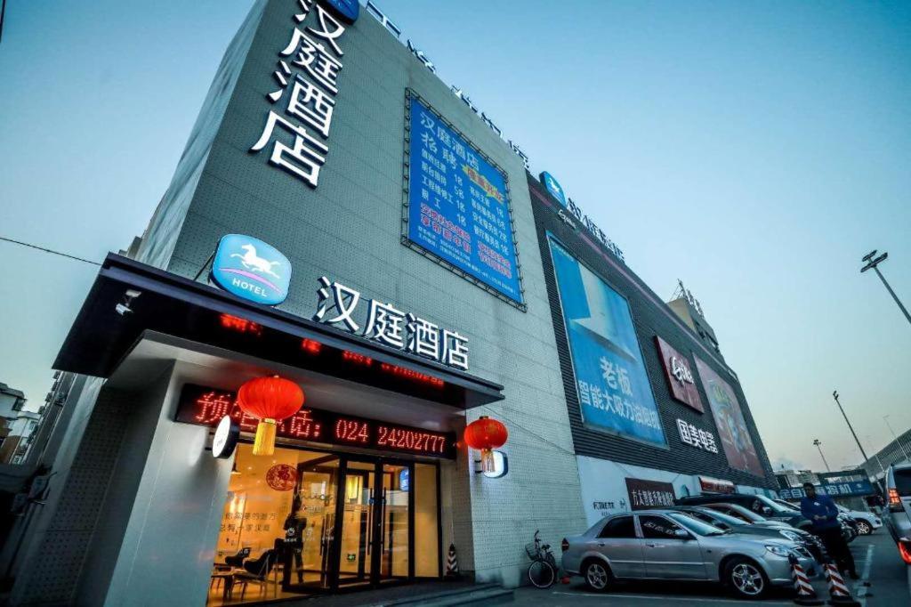 um edifício com um carro estacionado em frente em Hanting Hotel Shenyang Wanlian Metro Station em Shenyang