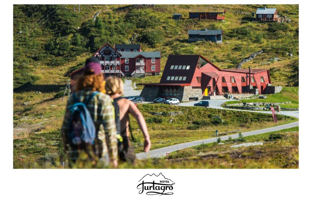 two people walking down a hill looking at a village at Turtagrø Hotel in Fortun
