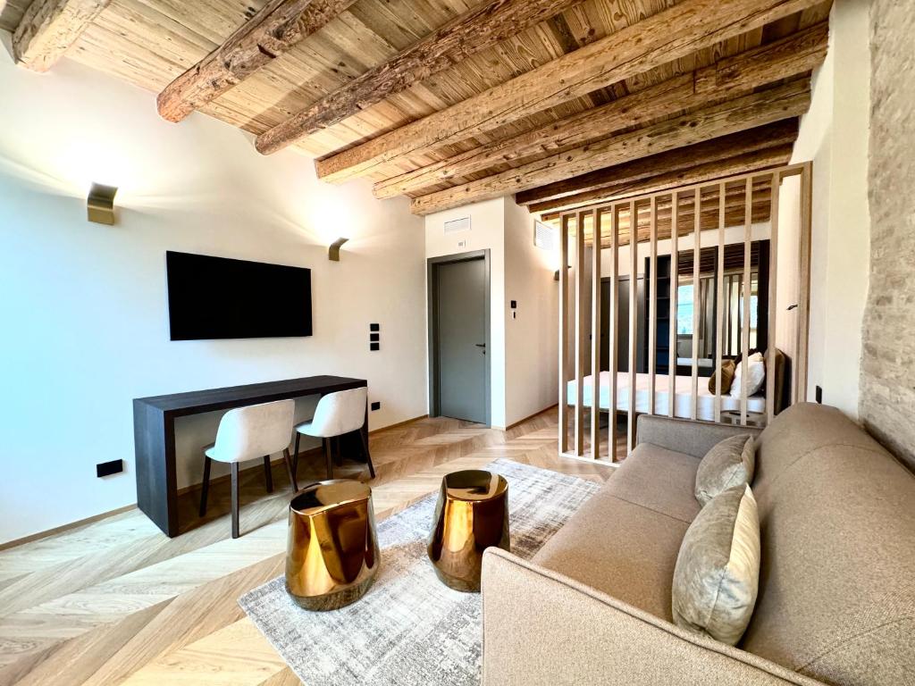 ein Wohnzimmer mit einem Sofa und einem TV in der Unterkunft Palazzo CarpeDiem-Prato della Valle in Padua