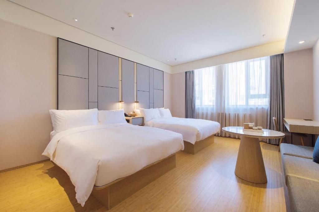 Un pat sau paturi într-o cameră la Ji Hotel Dalian Railway Station
