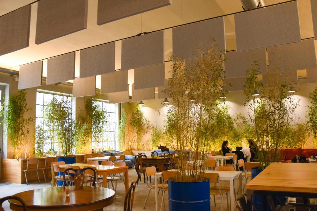 un restaurant avec des tables, des chaises et des plantes dans l'établissement Bovisa Urban Garden, à Milan