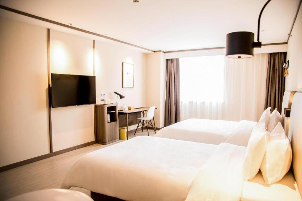 Łóżko lub łóżka w pokoju w obiekcie Hanting Hotel Yantai Development Zone Foxconn