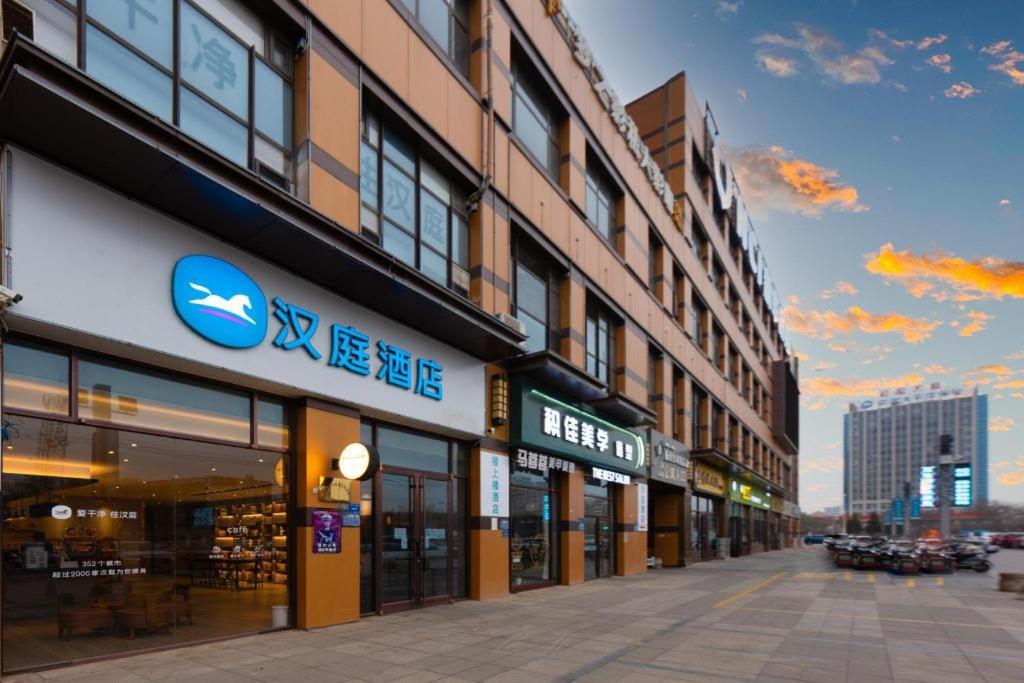 a city street with a building with a sign on it at Hanting Hotel Wuzhong Wanda Plaza in Wuzhong