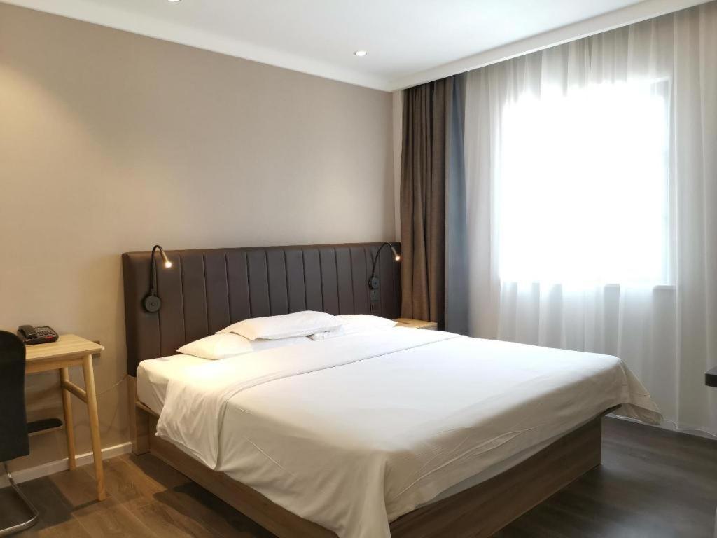 Una cama o camas en una habitación de Hanting Hotel Jiaxing Zhongshan Dong Road Babaiban