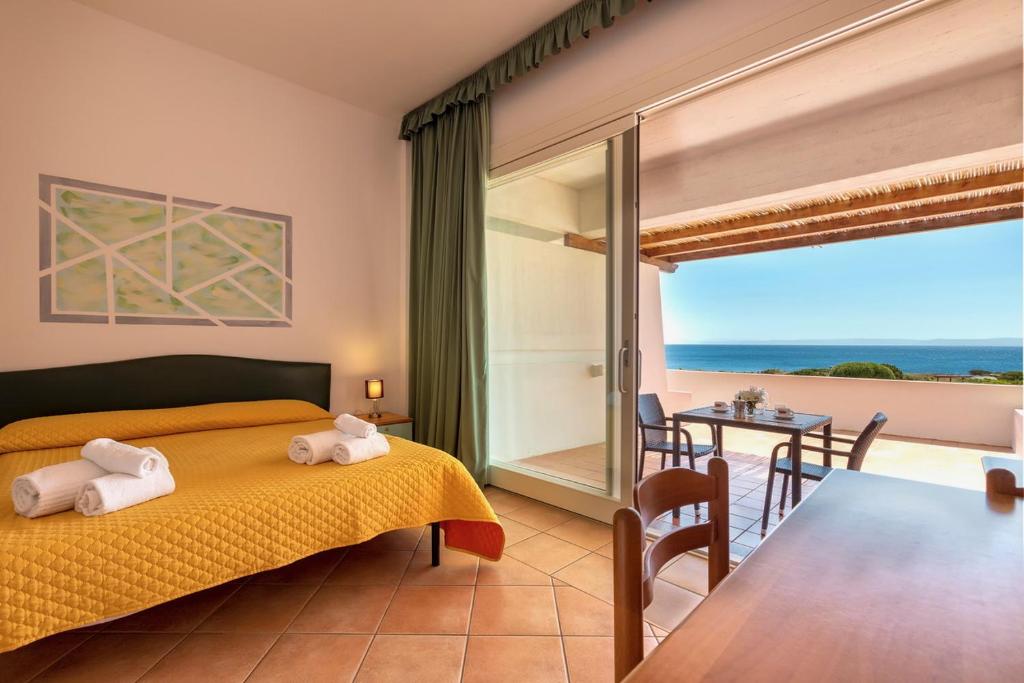 a bedroom with a bed and a view of the ocean at Residence Le Vele in Stintino