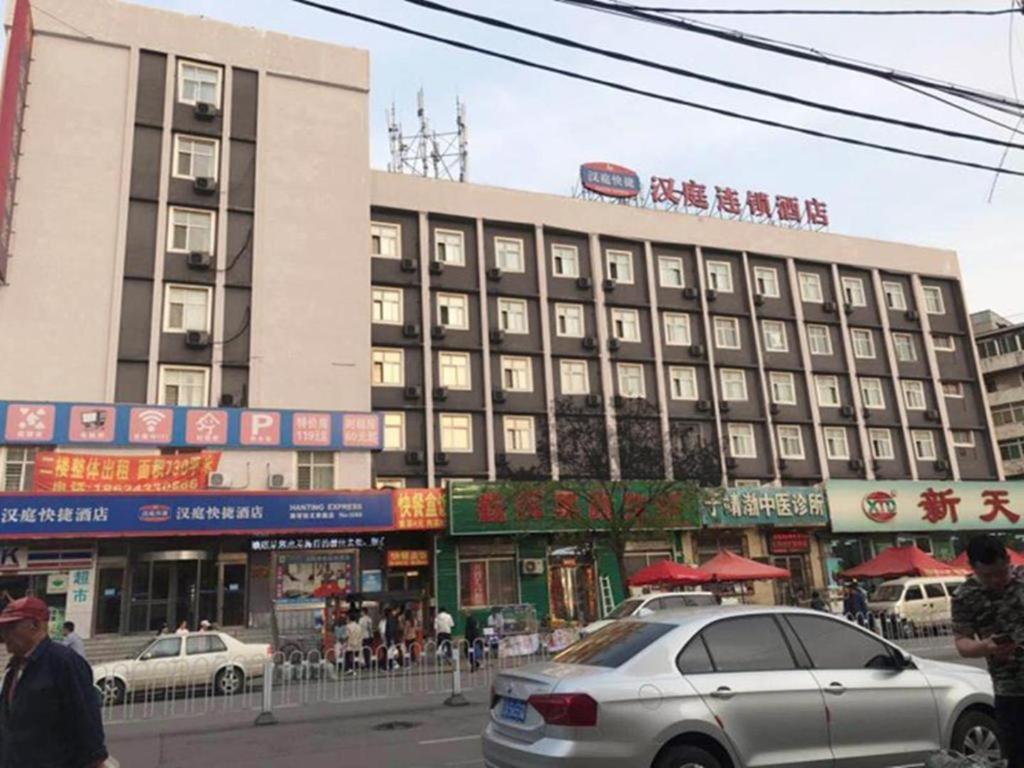 biały samochód zaparkowany przed budynkiem w obiekcie Hanting Hotel Shenyang Nanta Shoe Market w mieście Shenyang