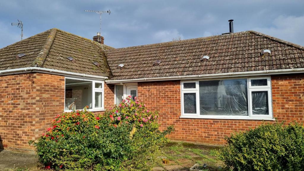 a brick house with white windows and a roof at Certa Cito in Heacham