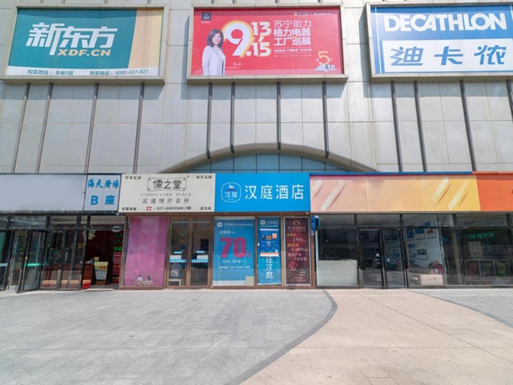 un edificio con letreros en el costado en Hanting Hotel Wuhan Wangjiawan Metro Station en Wuhan