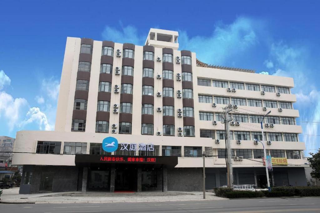 un grande edificio bianco con un cartello sopra di Hanting Hotel Zhijiang Yanjiang Avenue a Zhijiang