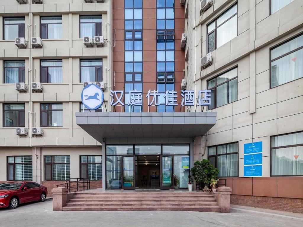 a building with a sign in front of it at Hanting Premium Hotel Qingdao Ocean University of China in Kutao