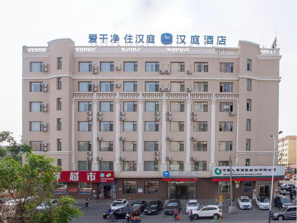 un grande edificio con auto parcheggiate in un parcheggio di Hanting Hotel Jilin Jiangbei Park a Jilin