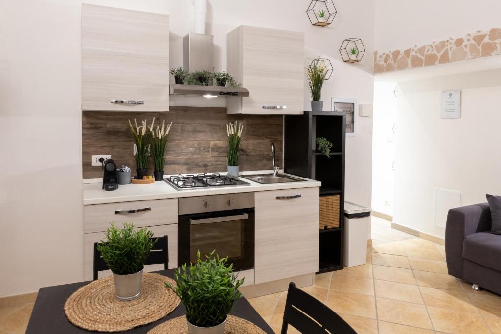 una cocina con armarios blancos y una mesa con plantas en Suite Gli Ulivi, en Colonna