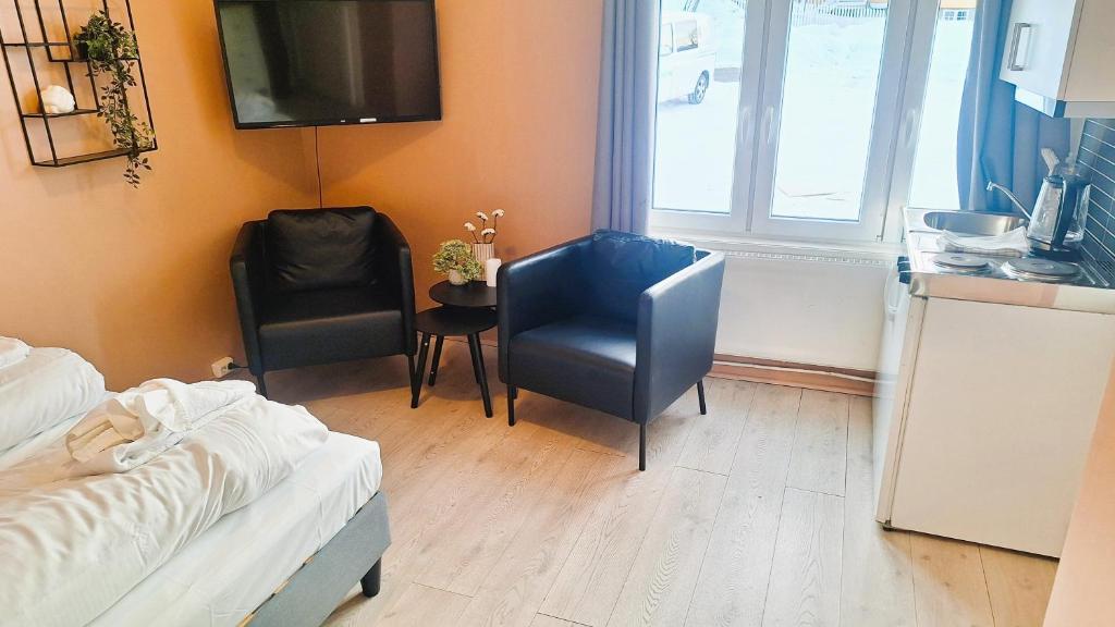 利勒哈默爾的住宿－Sentrumsnær leilighet - K1，一间带床和两把椅子的房间和一间厨房