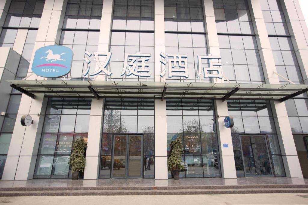 een gebouw met een bord aan de voorkant bij Hanting Hotel Nanyang Railway Station in Nanyang