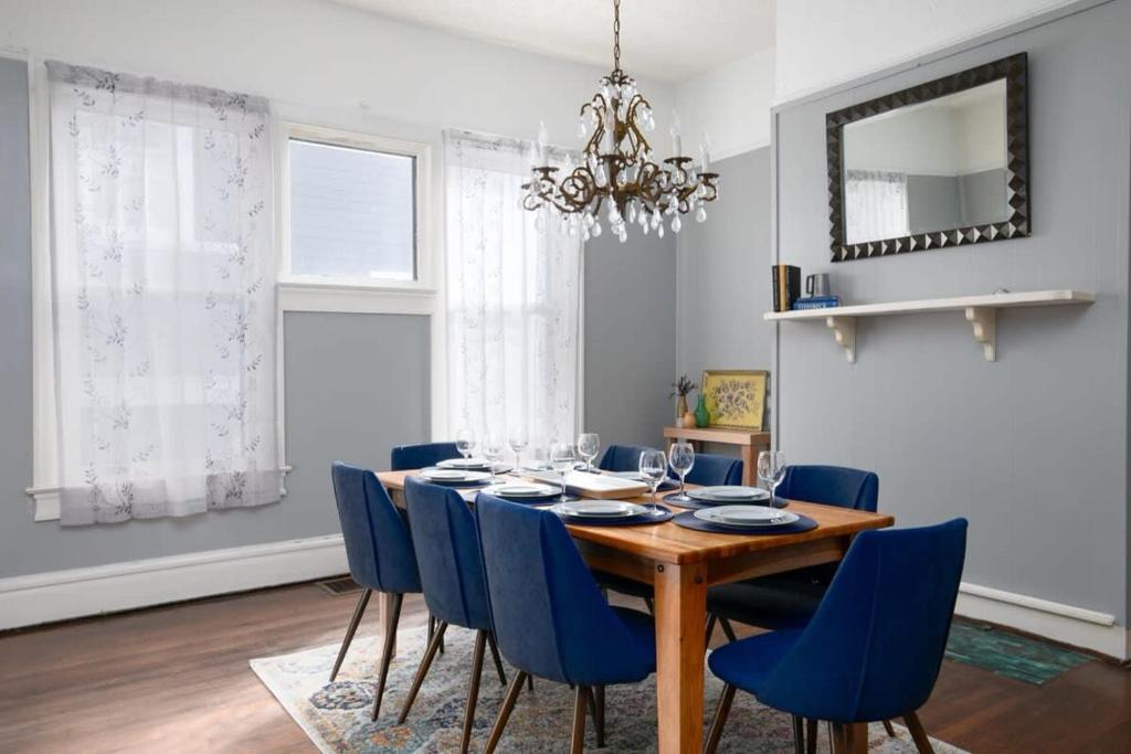 a dining room table with blue chairs and a chandelier at Magic on 17th Street- Historic, Close to UAB, UAB Hospital in Birmingham