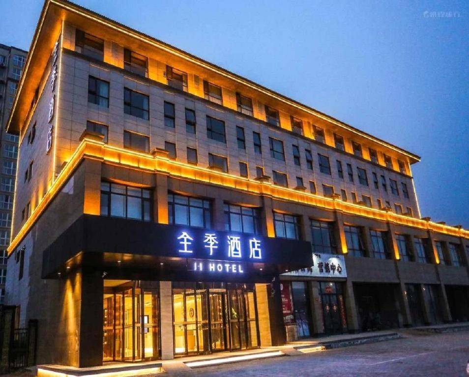 un edificio con un cartel en la parte delantera en JI Hotel Kaifeng Qingming Shanghe Garden Fuxing Avenue, en Kaifeng