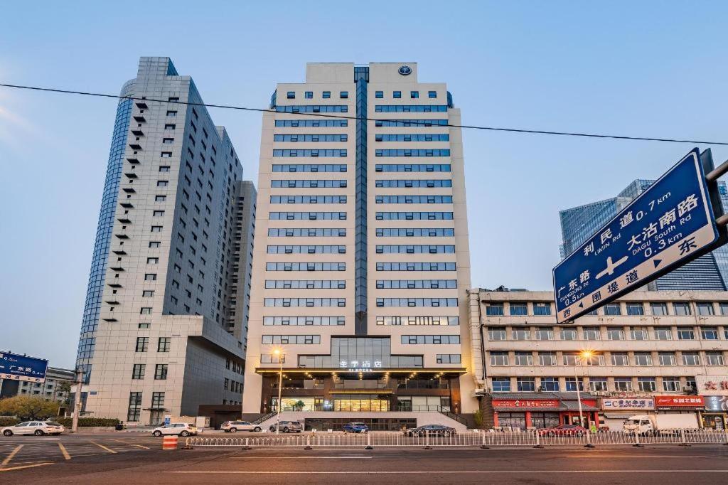 um edifício alto com uma placa de rua em frente em Ji Hotel Tianjin Cultural Center em Yutai