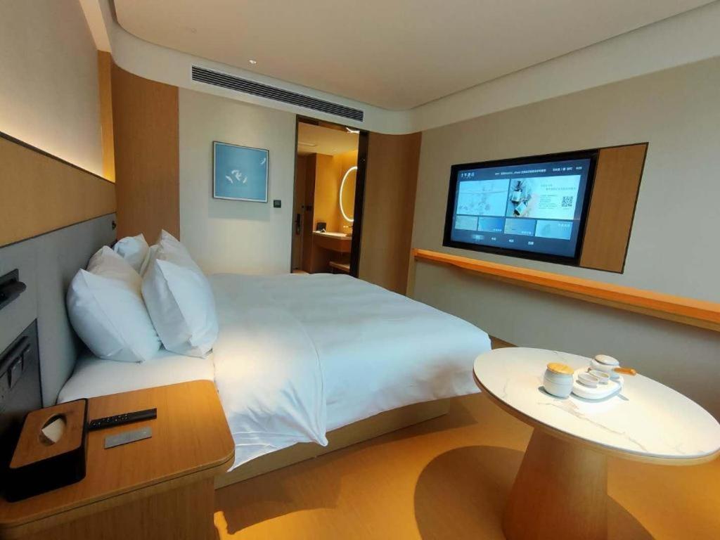XishuiにあるJi Hotel Zunyi Xishuiのベッドとテレビ付きのホテルルーム