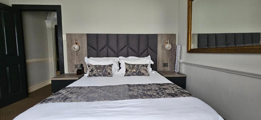 a bedroom with a large bed with white sheets and pillows at Luxe Florida Grand Hotel in Durban